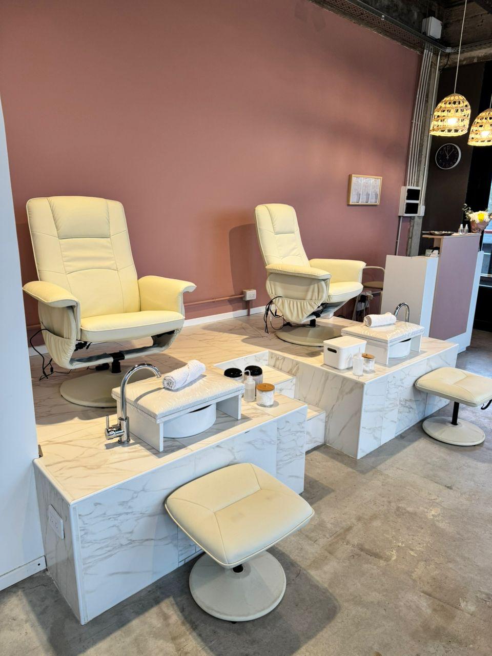 Estaciones de pedicura con sillones reclinables y bachas de mármol en Avanti Spa